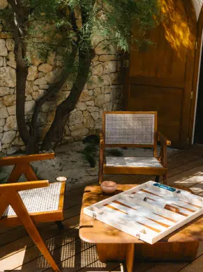 Espace lounge et backgammon du bar Indie Beach Ramatuelle, fauteuils rotin et mur en pierre s&egrave;che