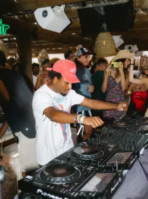 DJ masculin en casquette rouge sur Pioneer &ndash; beach club Indie Beach Ramatuelle